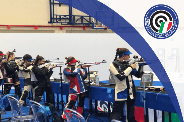 Atlete di tiro a segno impegnate sulla linea di tiro durante una competizione UITS.